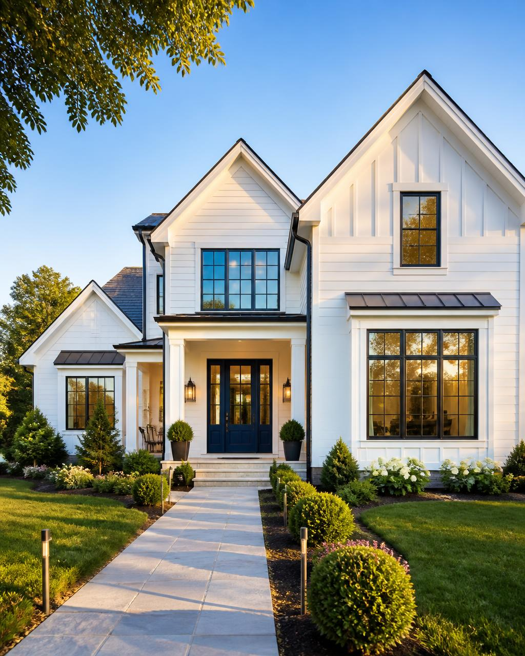 Bright white modern farmhouse with landscaped front walkway at golden hour